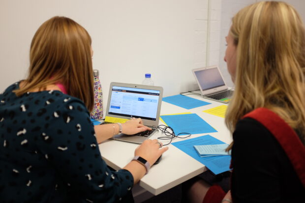 Two people sitting in front of a computer using the Content Data tool.