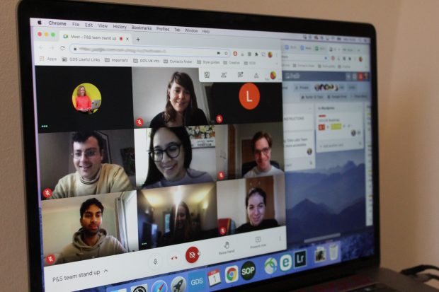 A laptop screen showing a team standup and a Trello board.