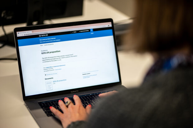 A laptop open to show the GOV.UK proposition page on GOV.UK with a person’s hands on the keyboard. 